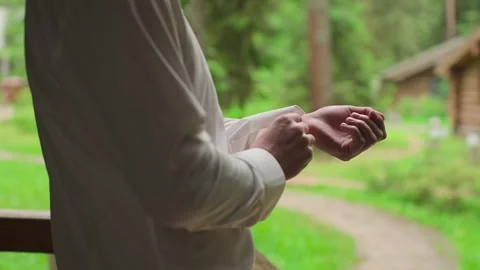 A young man buttoning the sleeves of his white shirt Stock Footage 328299180