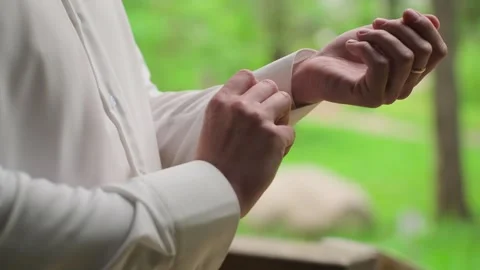 A young man buttoning the sleeves of his white shirt Video stock 328299182