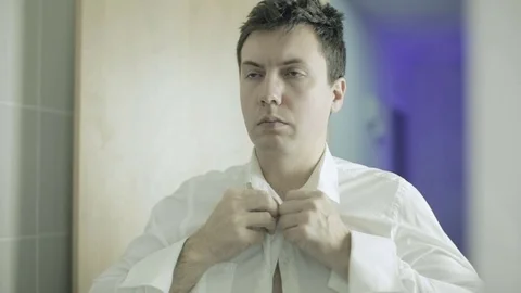 Young man buttoning white shirt buttons. Stock Footage 71314338