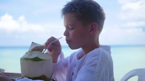 A young man in a cafe drinking a cocktail on terrace. outdoors Video stock 75909214