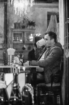 Young man in cafe drinking from cup Stock Photos