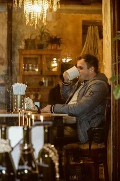 Young man in cafe drinking from cup Stock Photos