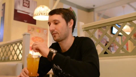 A young man in a cafe drinking lemonade Stock Footage 88830755