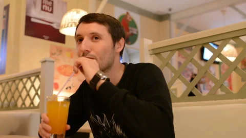 A young man in a cafe drinking lemonade Stock Footage 88831098