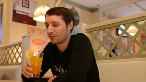 A young man in a cafe drinking lemonade Video stock 88833020