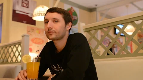 A young man in a cafe drinking lemonade Video stock 88833313