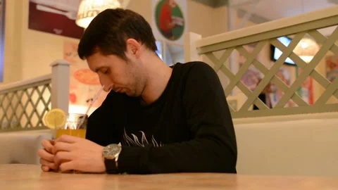 A young man in a cafe drinking lemonade Stock Footage 88835503