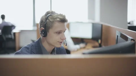 Young man call center agent speaking with costumer Видео 56823679