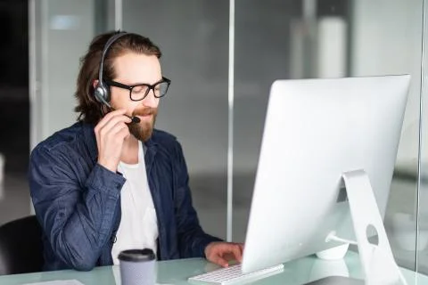 Young man call center agent speaking with costumer Stock Photos