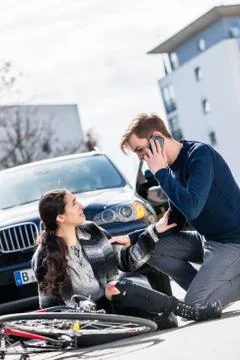 Young man calling the emergency services after hitting a bicyclist 스톡 사진