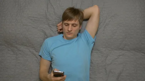Young Man Calling By Phone On Bed Stock Footage 106123345