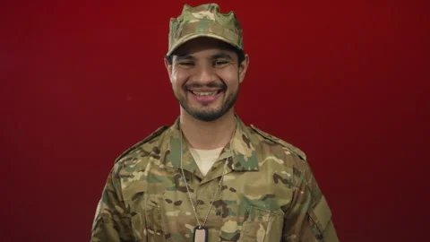 Young man in camouflage uniform claps hands and smiles facing camera in stu.. Stock Footage 313068302