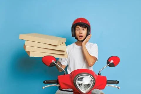 Young man can't make it on time, ready to ride red scooter, one hand pressed to Foto stock