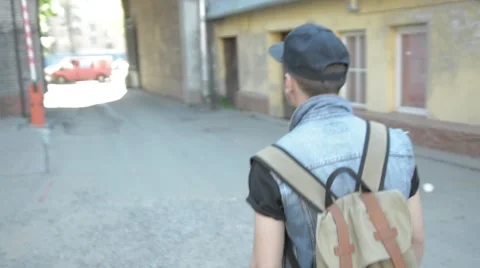 A young man in a cap goes in the direction arch Stock Footage 51757369