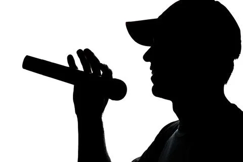 Young man in cap singing into a microphone Stock Photos