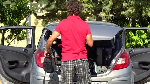 Young man in a car trunk loads Stock Footage 79895969