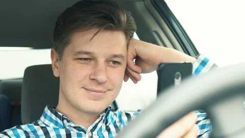 A young man in a car uses a mobile phone Stock Footage 105191059