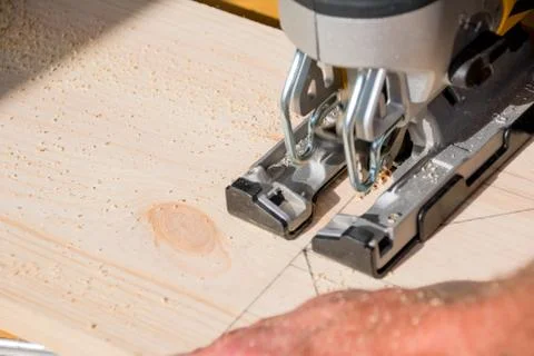 Young man carpenter builder working with electric jigsaw and wood.hobby concept Stock Photos