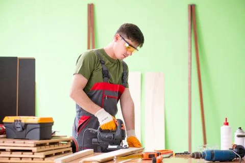 Young man carpenter working in workshop Fotos Stock
