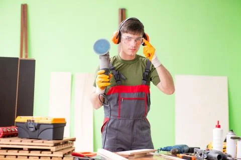 Young man carpenter working in workshop Fotos Stock