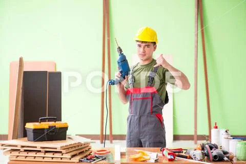 Young man carpenter working in workshop Stock Photos