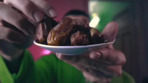 A young man carrying dates in preparation for breaking the fast during Ramadan Stock Footage 299574462
