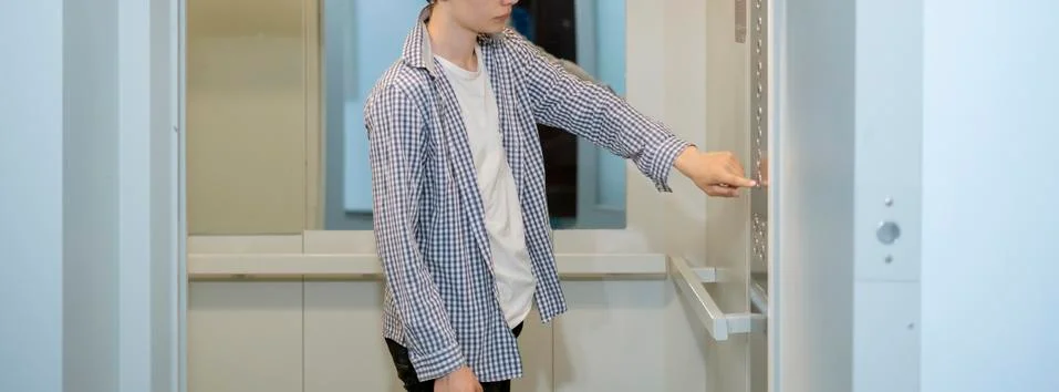 A young man in casual come inside the lift elevator cabin Stock Photos