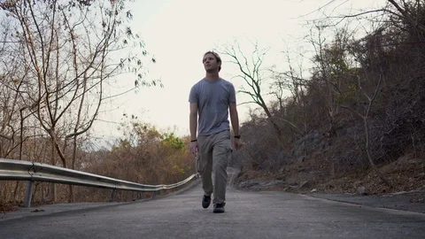 Young Man Casually Hiking on Empty Mountain Road during Summer Video stock 127921271