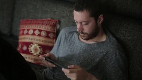 Young Man Casually Playing Video Games on Couch Stock Footage 76700168