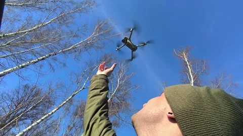A young man catches a quadcopter through the car hatch Stock Footage 269484951
