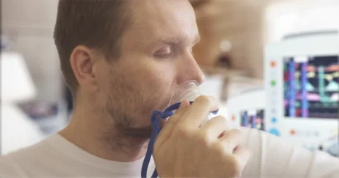 Young Man is Caughing Breathing Through Nebulizer Mask Parameters Displayed on Stock Footage 57922821