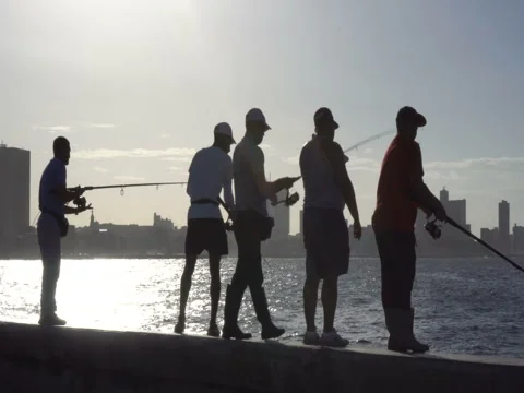 Young man caught a fish on the pier at sunset Stock Footage 70991884
