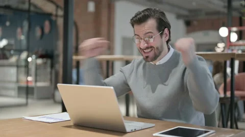 Young Man Celebrating Success while using Laptop in Office Stock Footage 161315522