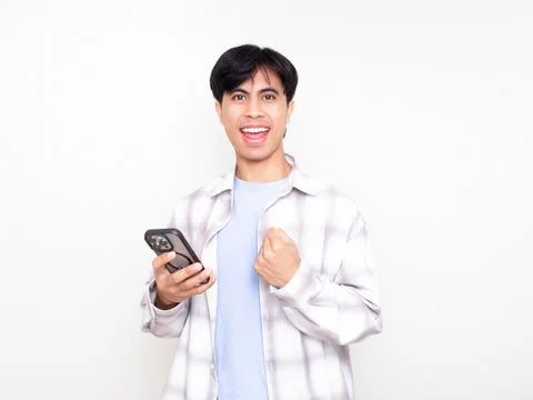 Young man celebrating while checking his smartphone, showing excitement abo.. Stock Photos