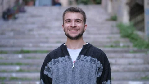 Young man changes his expression and laughs at the camera in a funny way Stock Footage 231676592