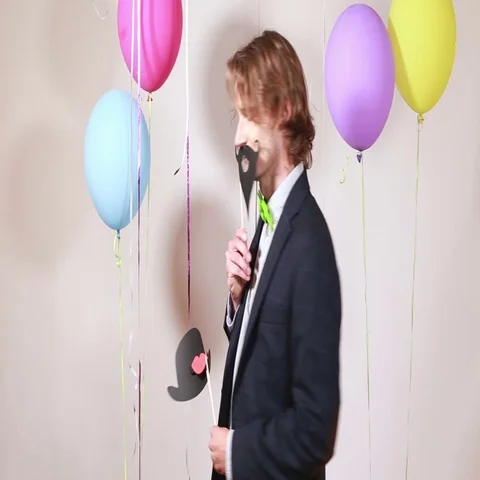 Young man changing props in photo booth Stock Footage 69303868