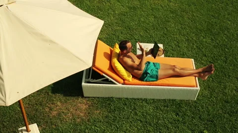 Young man chating on tablet computer during relax on sunbed  HD Vídeo Stock 40901894