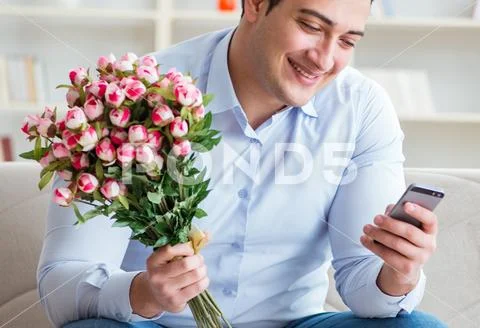 Young man chatting with his sweetheart over mobile phone Stock Photos