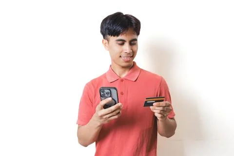 Young man checking details while making an online purchase using a smartpho.. Stock Photos