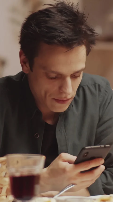 Young Man Checking E-mail Inbox on Smartphone after Home Dinner Party Stock Footage 299538343