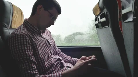 Young man checking emails on his commute to a job by the bus in a long trip Stock Footage 75945347