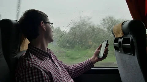 Young man checking emails on his commute to a job by the bus in a long trip Stock Footage 75999335