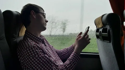 Young man checking emails on his commute to a job by the bus in a long trip Stock Footage 75999995
