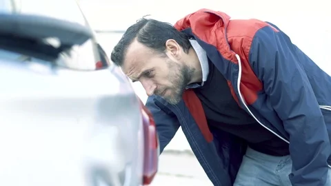 Young man checking his car for scratches and calls for help. Stock Footage 105440625