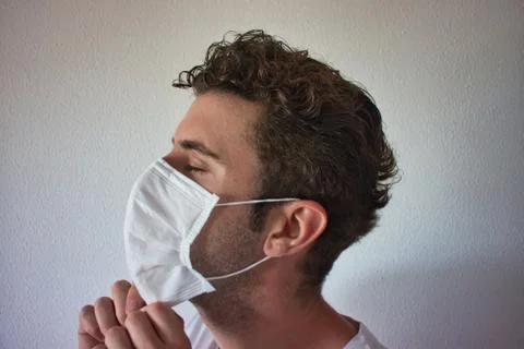 Young man checking if his mask is in good position Stock Photos