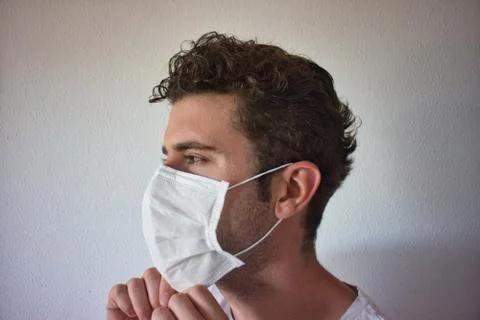 Young man checking if his mask is in good position Stock Photos