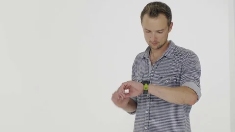 Young man checking the messages on smart watches in the studio 스톡 동영상 80355570
