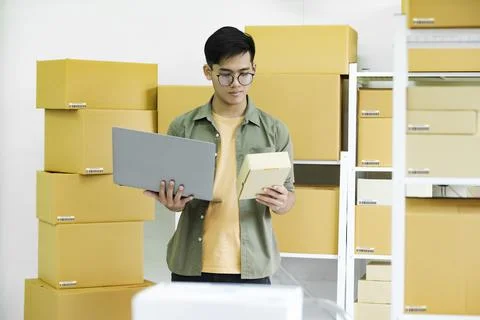 Young man checking parcel address using laptop. 写真素材
