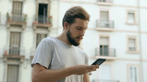 Young Man Checking Smartphone Outdoors Stock Footage 129343925