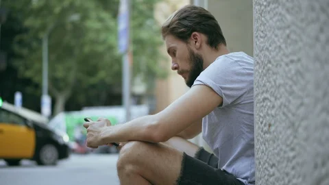 Young Man Checking Smartphone Outdoors Stock Footage 129344581